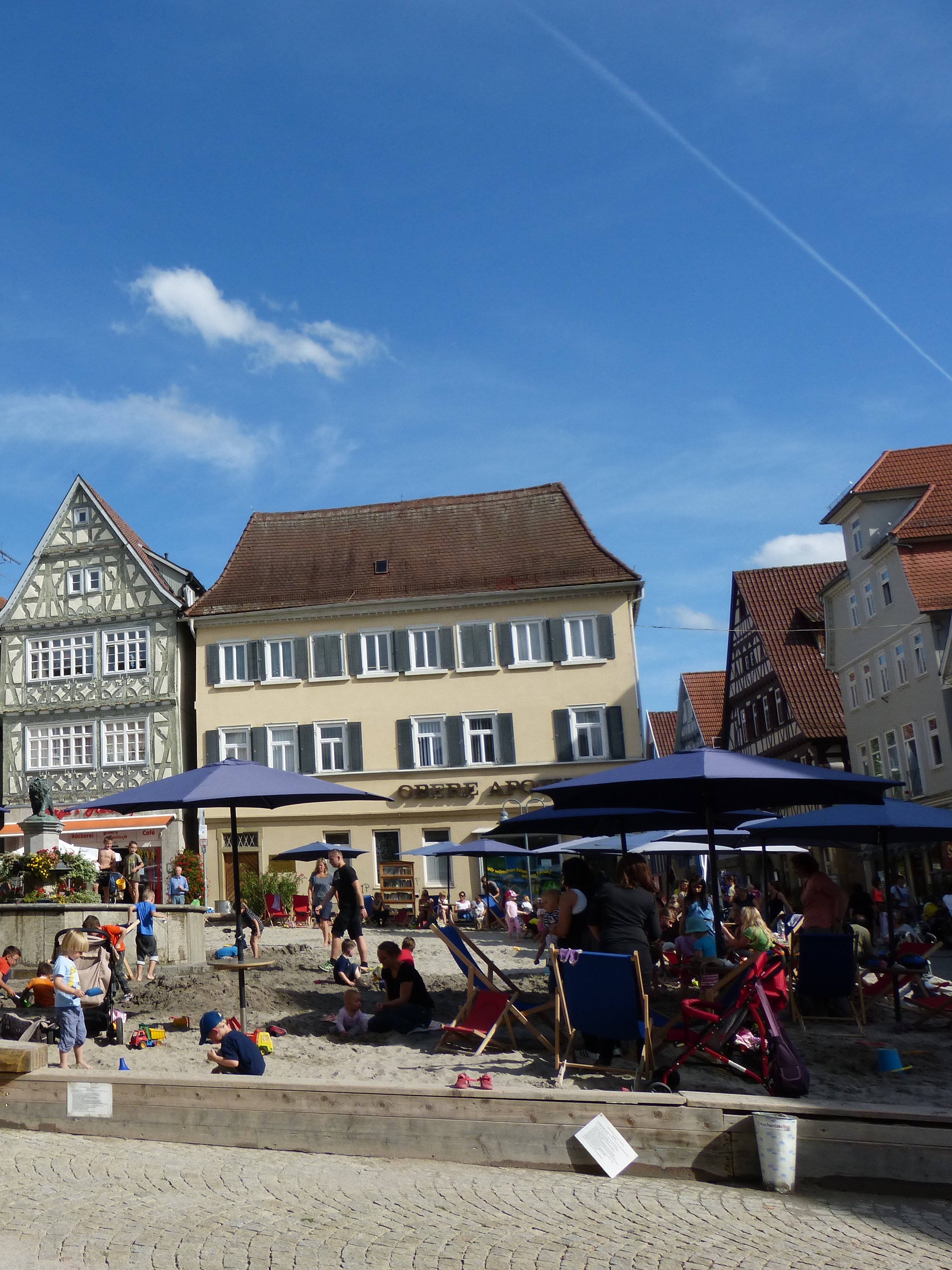 Der Vaihinger Marktplatz mit großem Sandkasten und Sonnenschirmen